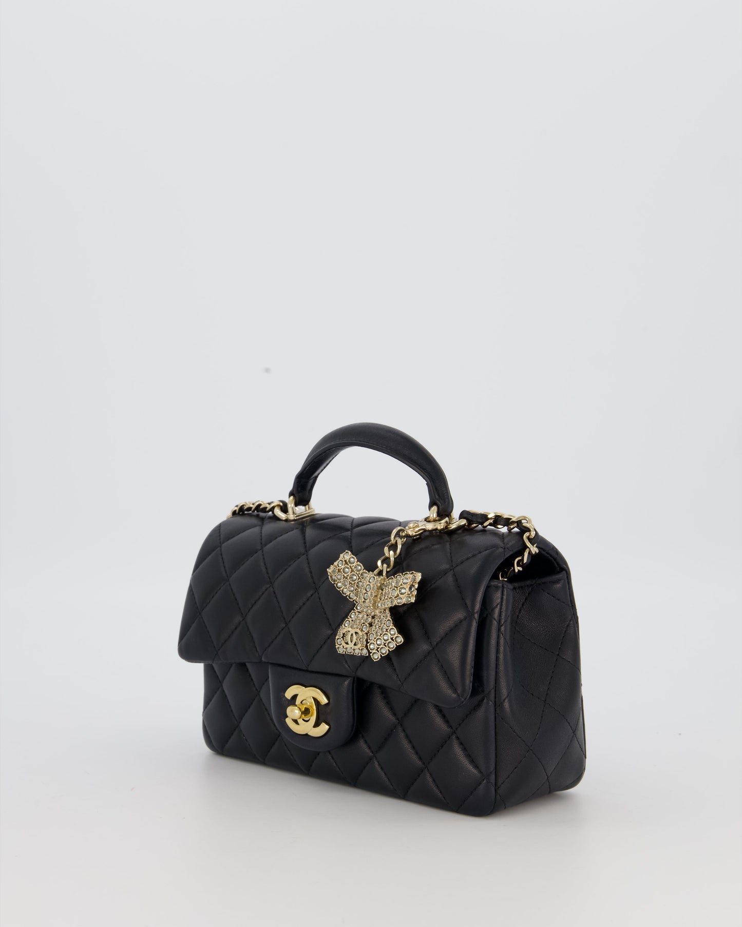 Chanel Black Mini Rectangular Top Handle Flap Bag in Lambskin Leather with Champagne Hardware and Strass Removable Bow Charm